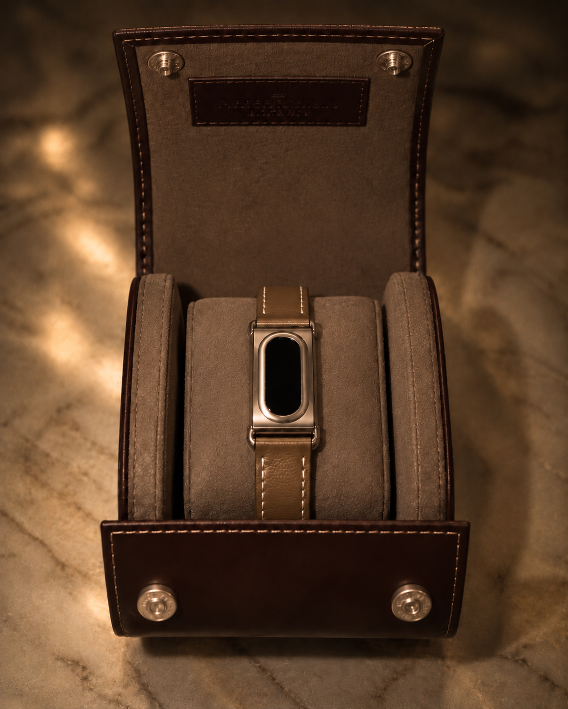 The Prenup band in Dark Brown vegan leather with a metal case, displayed in a leather watch box