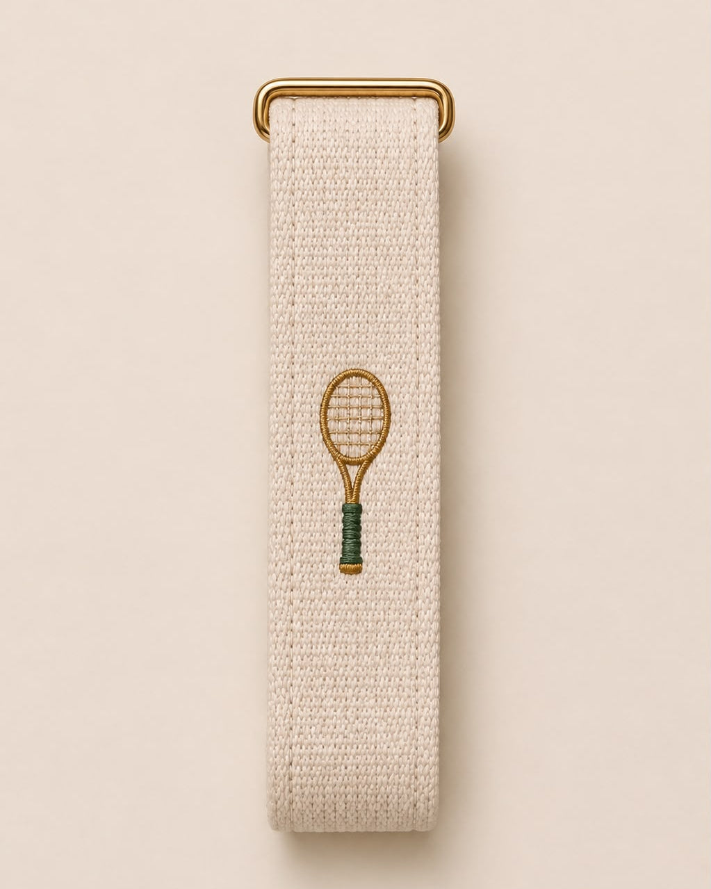 Court Side band laid flat, showing the embroidered tennis racket and gold-tone buckle